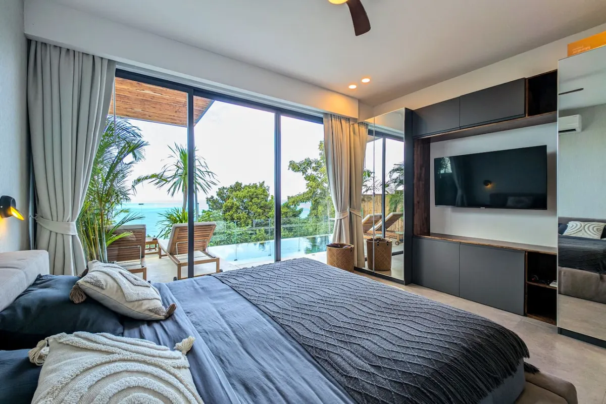 Omi Villa, Haad Yao area — bedroom opening to a sea-view balcony — Crazy GAKKO Stay